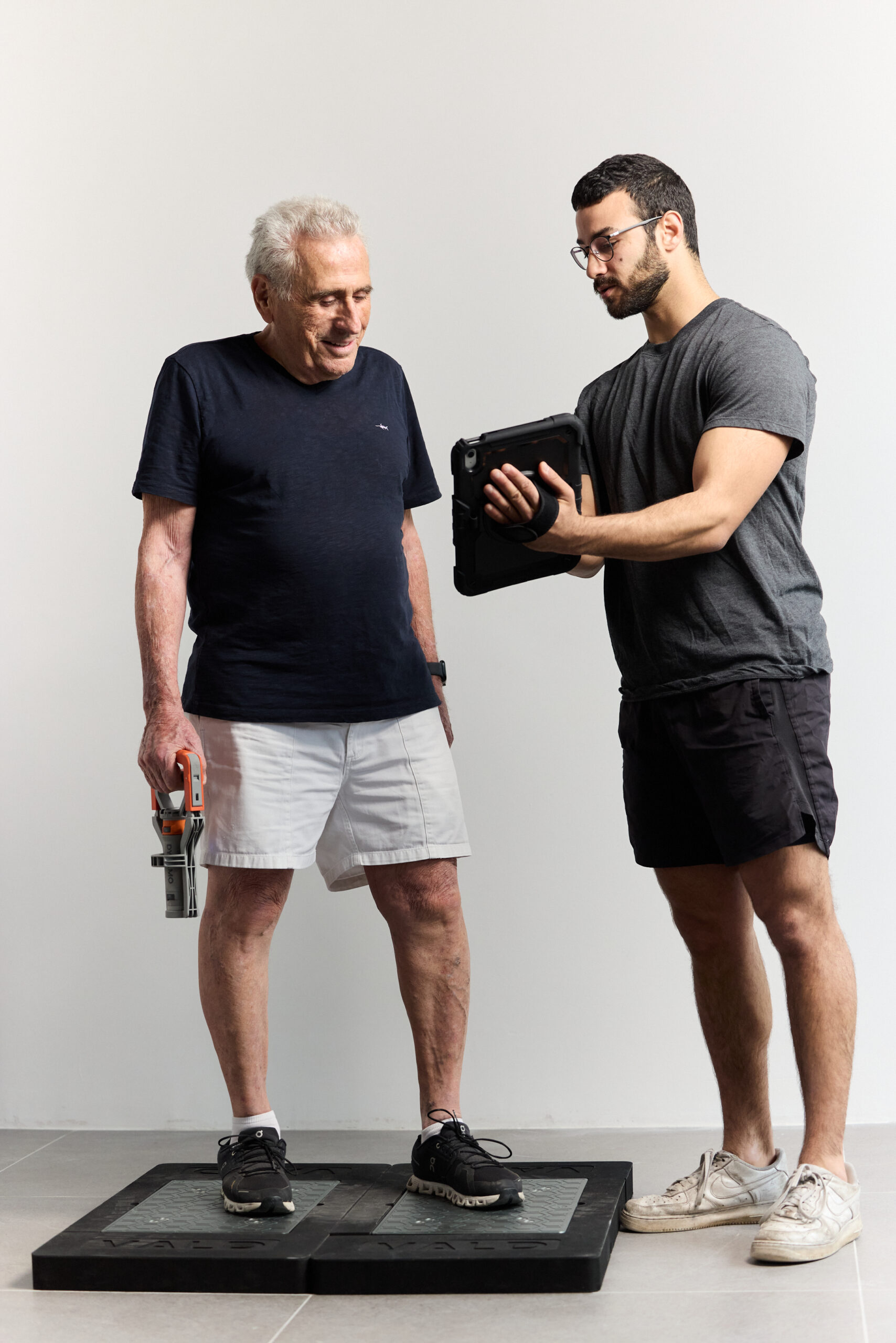 performance coach reviewing training data on tablet with client